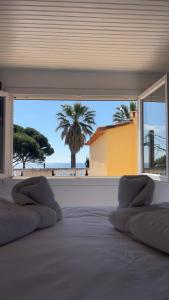 a bedroom with a bed with a view of the beach at Hôtel L'Escale Au Soleil in Saint-Aygulf +102 photos