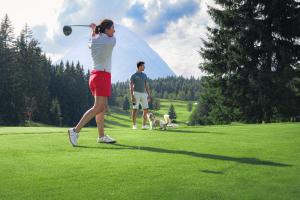 a man and a woman playing golf with a dog at Appartement Weiskopf in Reith bei Seefeld