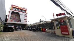 a building with cars parked in a parking lot at Hotel Quds Express Syariah in Jakarta