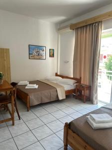 a hotel room with two beds and a table at OLGA STUDIOS in Olympic Beach