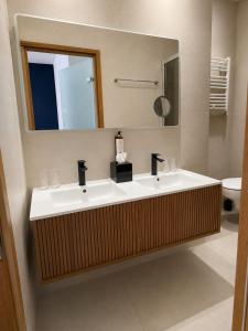 a bathroom with two sinks and a mirror at Hotel De La Mer in Nice