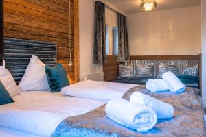 two beds in a room with white sheets and pillows at Das Thiers in Thiersee