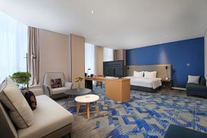 a hotel room with a bed and a couch at Holiday Inn Express Linyi West by IHG in Linyi