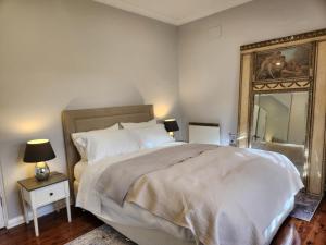 a bedroom with a large bed and a mirror at Bowral Central Garden Apartment in Bowral