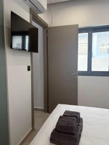 a room with a bed with two towels on it at Coralli Beachfront in Pefki