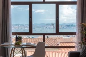a window with a table and a view of the water at El Balcon de Moaña in Moaña