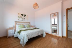 a white bedroom with a bed and a mirror at El Balcon de Moaña in Moaña +4 photos