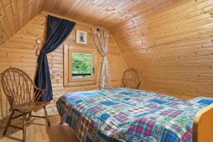 a bedroom with a bed and a window in a log cabin at Fairy Tale House in Trenta +37 photos