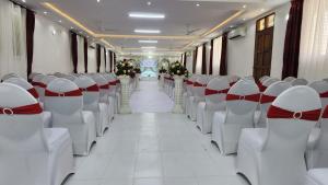 an empty train car aisle with white chairs and flowers at Prestige Leisure Hotel in Mtwapa +56 photos