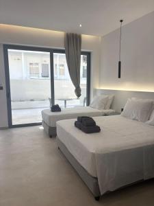 a bedroom with two beds and a table in it at Coralli Beachfront in Pefki