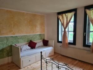 a room with a couch and two windows at Große Ferienwohnung 160qm in einzigartigem historischen 700 Jahre altem Gebäude in Hardegsen