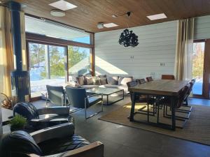 a living room with a table and chairs at Luksushuvila yksityisellä SPA-alueella ja järvinäköalalla in Ähtäri