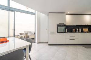 a kitchen with white cabinets and a table with chairs at Secret Garden in Vias +20 photos