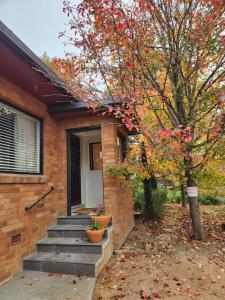 a brick house with stairs and a tree at Bowral Central Garden Apartment in Bowral