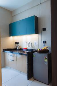 a kitchen with a sink and a refrigerator at Nirrtul Crystal 1BHK Apartment Cozy & Quite in Surat