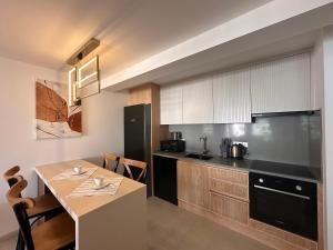 a kitchen with a table and a black refrigerator at Mykonos Homes Cyprus in Kyrenia