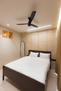 a bedroom with a bed with a ceiling fan at Nirrtul Crystal 1BHK Apartment Cozy & Quite in Surat