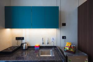 a kitchen with a sink and a counter top at Nirrtul Crystal 1BHK Apartment Cozy & Quite in Surat +5 photos