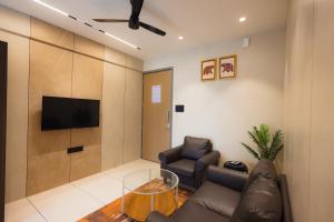 a living room with a couch and a tv at Nirrtul Crystal 1BHK Apartment Cozy & Quite in Surat