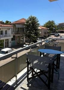 a table and bench on the balcony of a building at Thouria Agora Suites 2 10 min from Kalamata Ideal Base for Exploring Messinia in Kalamata
