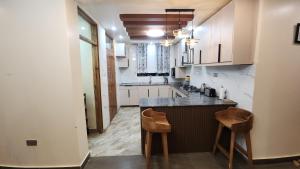 a kitchen with a counter and two chairs in it at Blooming Sanctuary in Ruiru