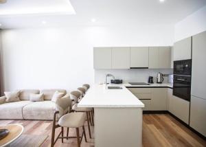 a white kitchen with a couch and a table at Aqualina D5-1 by HolidayKeys in Kyrenia
