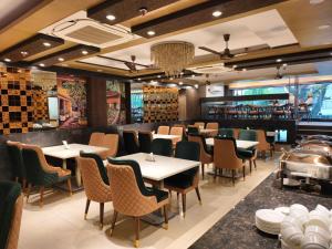a restaurant with tables and chairs and a bar at Jakk Residency, ILBS Hospital in New Delhi
