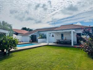 a house with a yard with a swimming pool at Villa between forest and ocean in Labenne