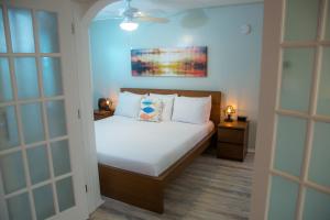 a bedroom with a bed with white sheets and pillows at St. Pete Beach Suites in St Pete Beach
