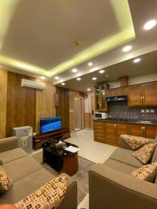 a living room with two couches and a kitchen at Al Mansi hotel in Amman
