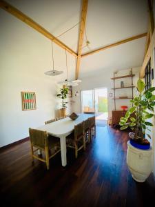 a dining room with a table and chairs and a plant at Villa between forest and ocean in Labenne