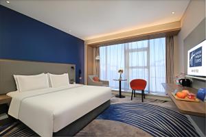 a hotel room with a large bed and a desk at Holiday Inn Express Linyi West by IHG in Linyi +59 photos