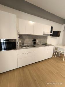 a kitchen with white cabinets and a sink and a table at dante 55 in Agrigento