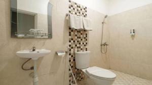 a bathroom with a toilet and a sink at Hotel Quds Express Syariah in Jakarta +6 photos