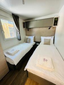 two twin beds in a small room with a window at Iris Holiday Homes in Biograd na Moru