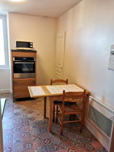 a small kitchen with a wooden table and a stove at Studio au coeur pays basque in Ustaritz +8 photos