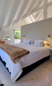 a large bed in a white room with a large bed sidx sidx sidx at St Francis Cottage close to beach in St Francis Bay