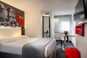 a hotel room with a large bed and a table at Hôtel Gustave Colmar in Colmar