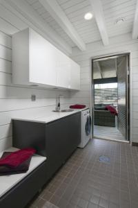 a kitchen with a sink and a washing machine at Arkkitehtihuvila järvinäköalalla 5 makuuhuonetta ja tilauspalveluna ulkoporeallas in Ähtäri