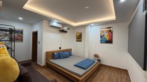 a small bedroom with a bed with blue pillows at Nắng Hotel in Cẩm Mỹ +28 photos