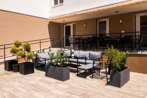 a patio with chairs and tables on a building at Hotel Crystal in Hajdúszoboszló