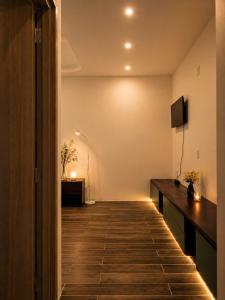 a room with a hallway with a desk and a television at Bareka Hotel in Phú Quốc
