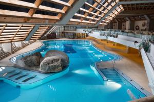a large swimming pool with a rock in the middle at Appartement Weiskopf in Reith bei Seefeld