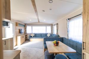 a living room with a blue couch and a table at Brynteg Coastal & Country Retreat in Caernarfon