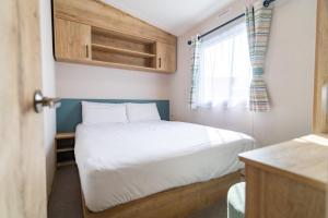 a small bedroom with a bed and a window at Brynteg Coastal & Country Retreat in Caernarfon +37 photos