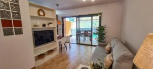 a living room with a couch and a television at Jardín del Teide in Puerto de la Cruz