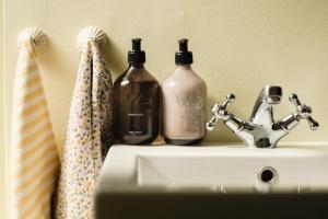three bottles sitting on top of a bathroom sink at Hotel Villa Lejet in Tisvilde