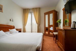 a hotel room with a bed and a window at Hotel Sarmis in Deva +23 photos