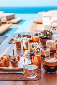 a wooden table with food and drinks on it at Tropicana Hotel Mykonos in Paradise Beach