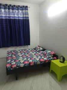 ein Bett in einem Zimmer mit einem blauen Vorhang in der Unterkunft Rana Complex in Nādaun